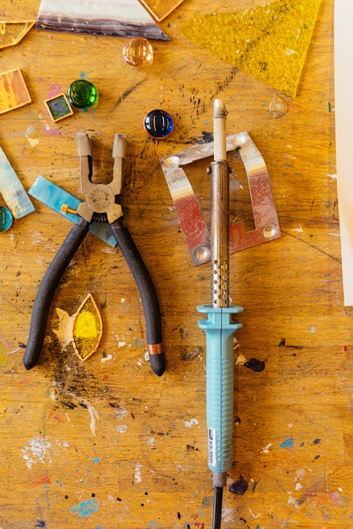 Top view of crafting tools and materials on a wooden table.