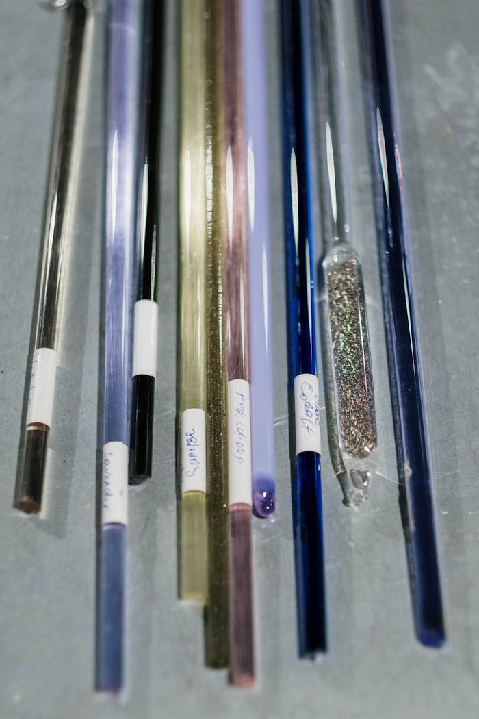 A detailed close-up of various colorful glass rods and samples arranged vertically.
